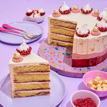 Raspberry & White Chocolate Cake with four layers, raspberry ripple sponge, white chocolate buttercream, and gold leaf decoration.